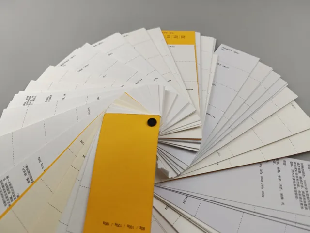 Paper swatch fan · yellow cover; photographed paper sample book with original labels